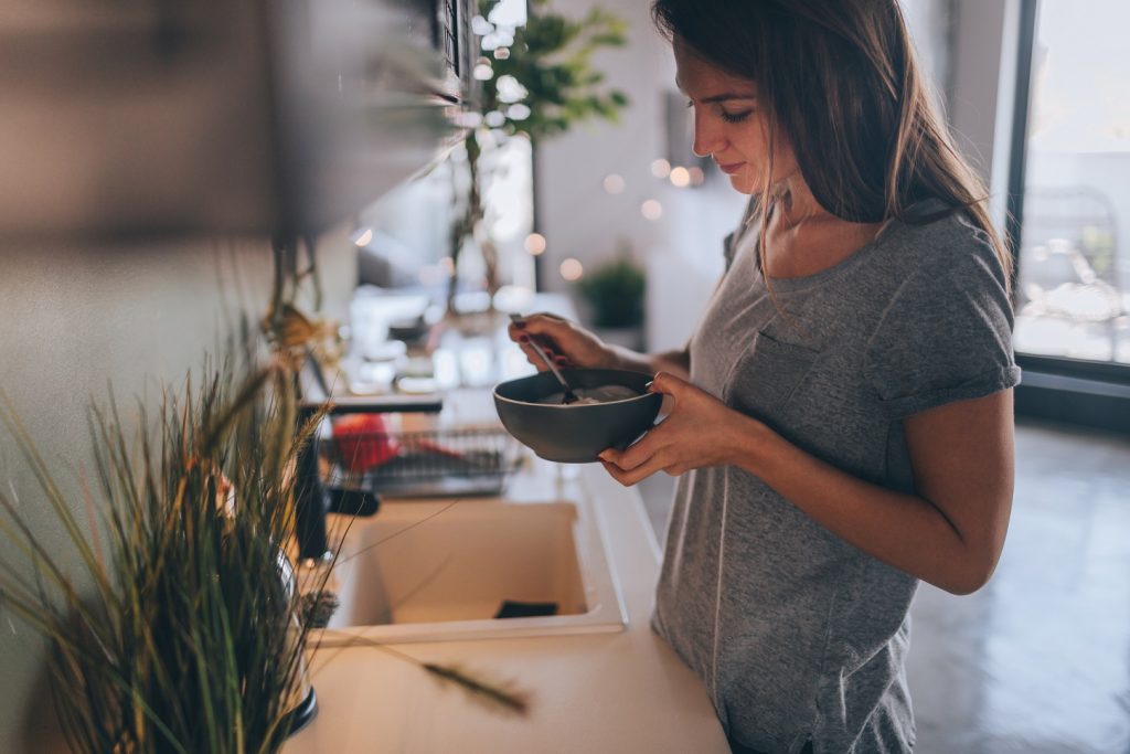 Young woman having healthy breakfast in the morning in her apartment.