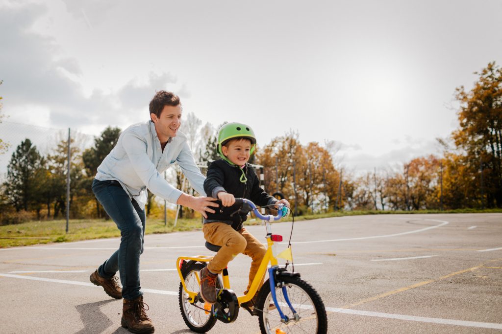 A father teaching his child how to ride a bike.